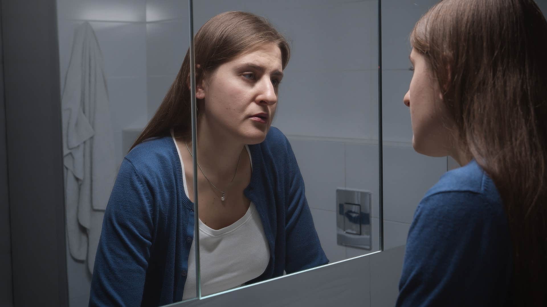 woman looking in mirror with a fear of aging 