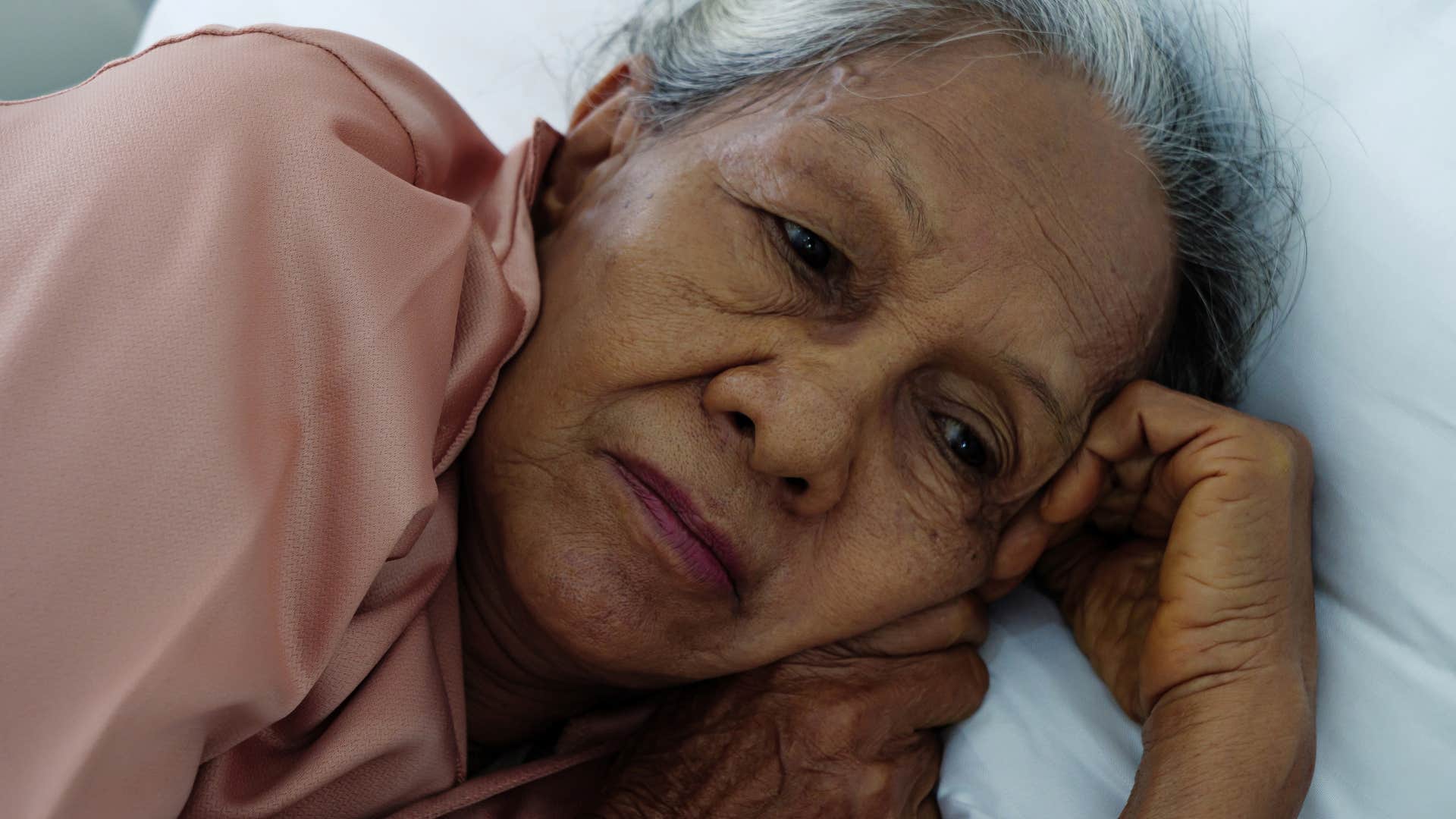 woman who fears the silence of bedtime lying awake in bed