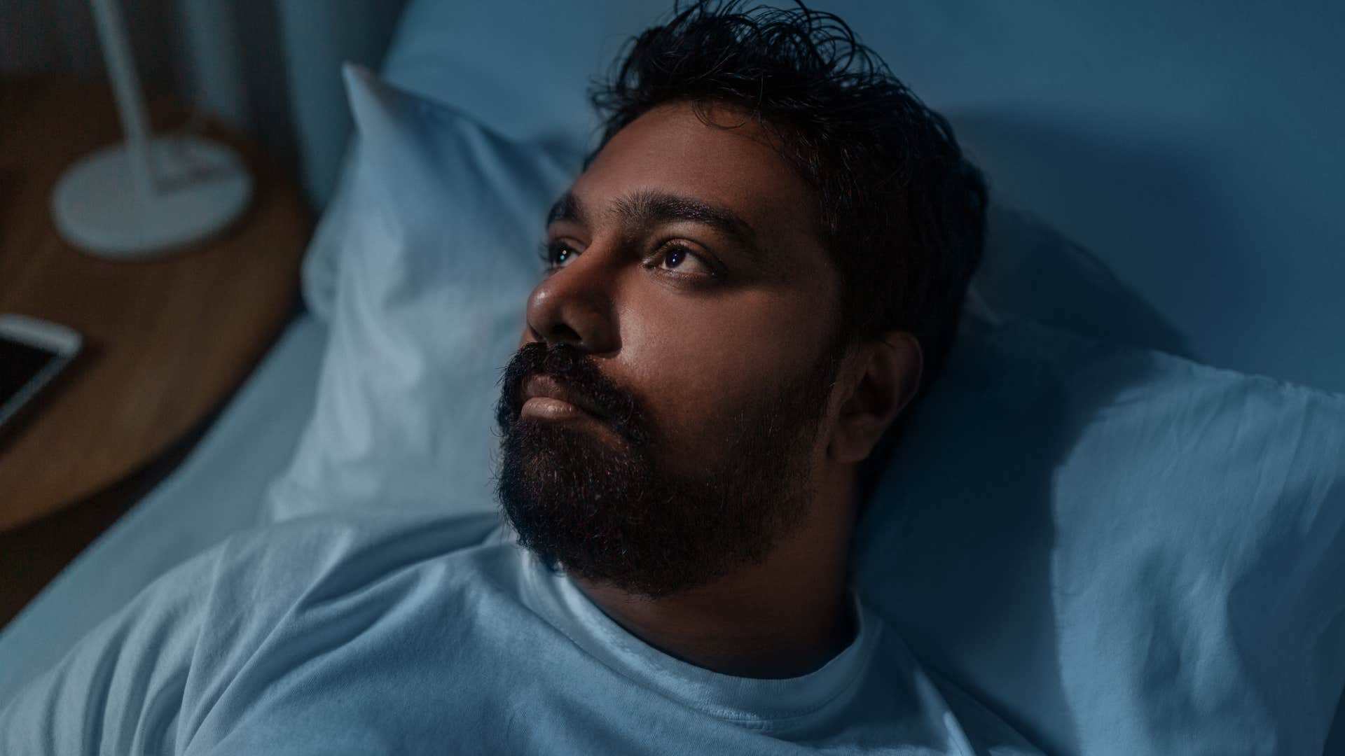 man worried about wasting time lying awake in bed