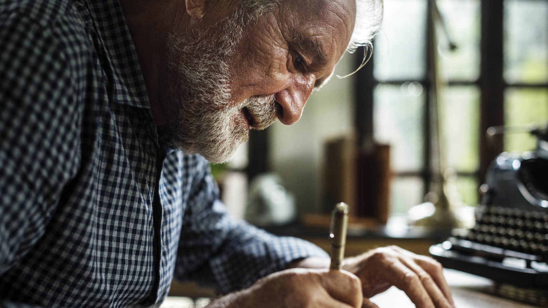 man who values connection writing letters at home