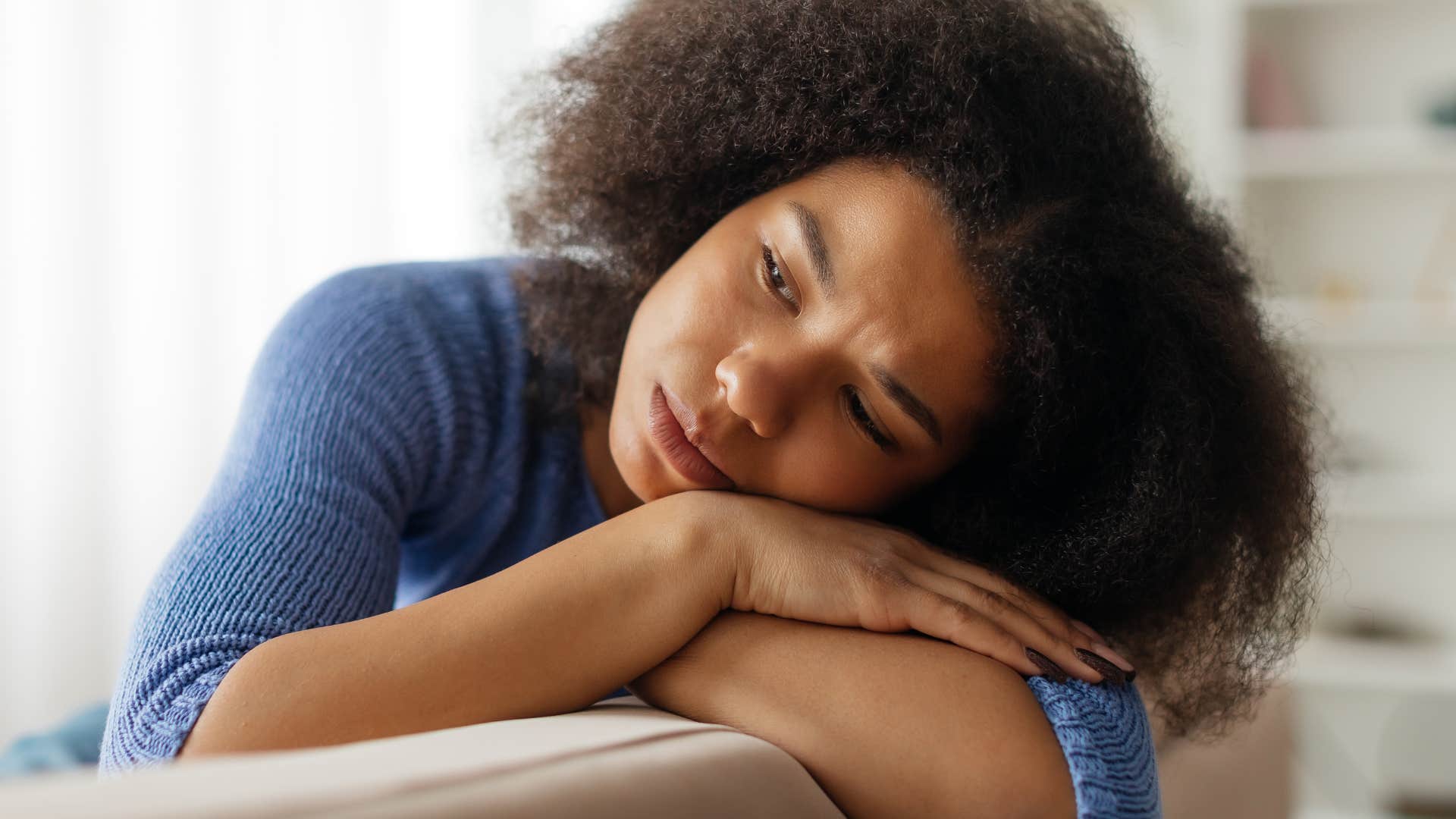 exhausted woman who's selective with her energy lying on the couch
