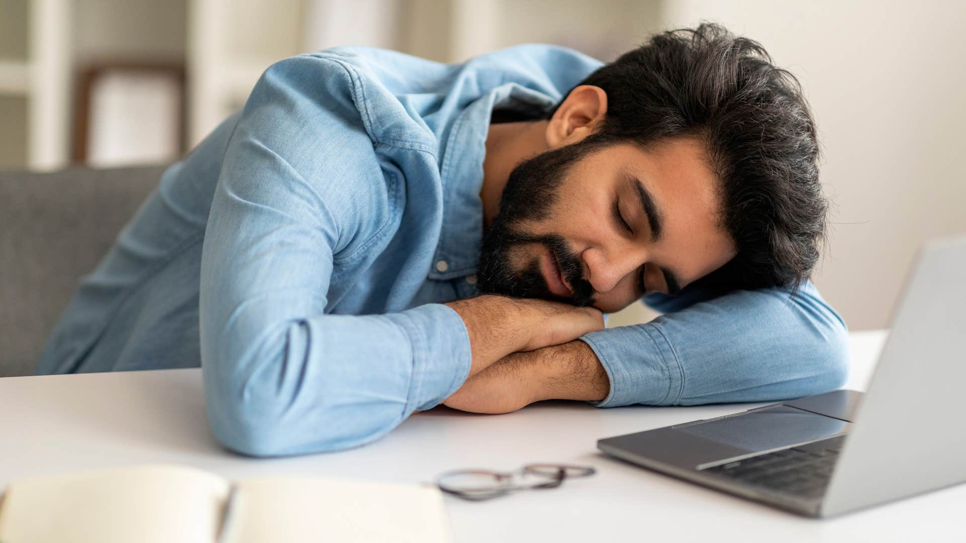 man taking a nap while working on laptop