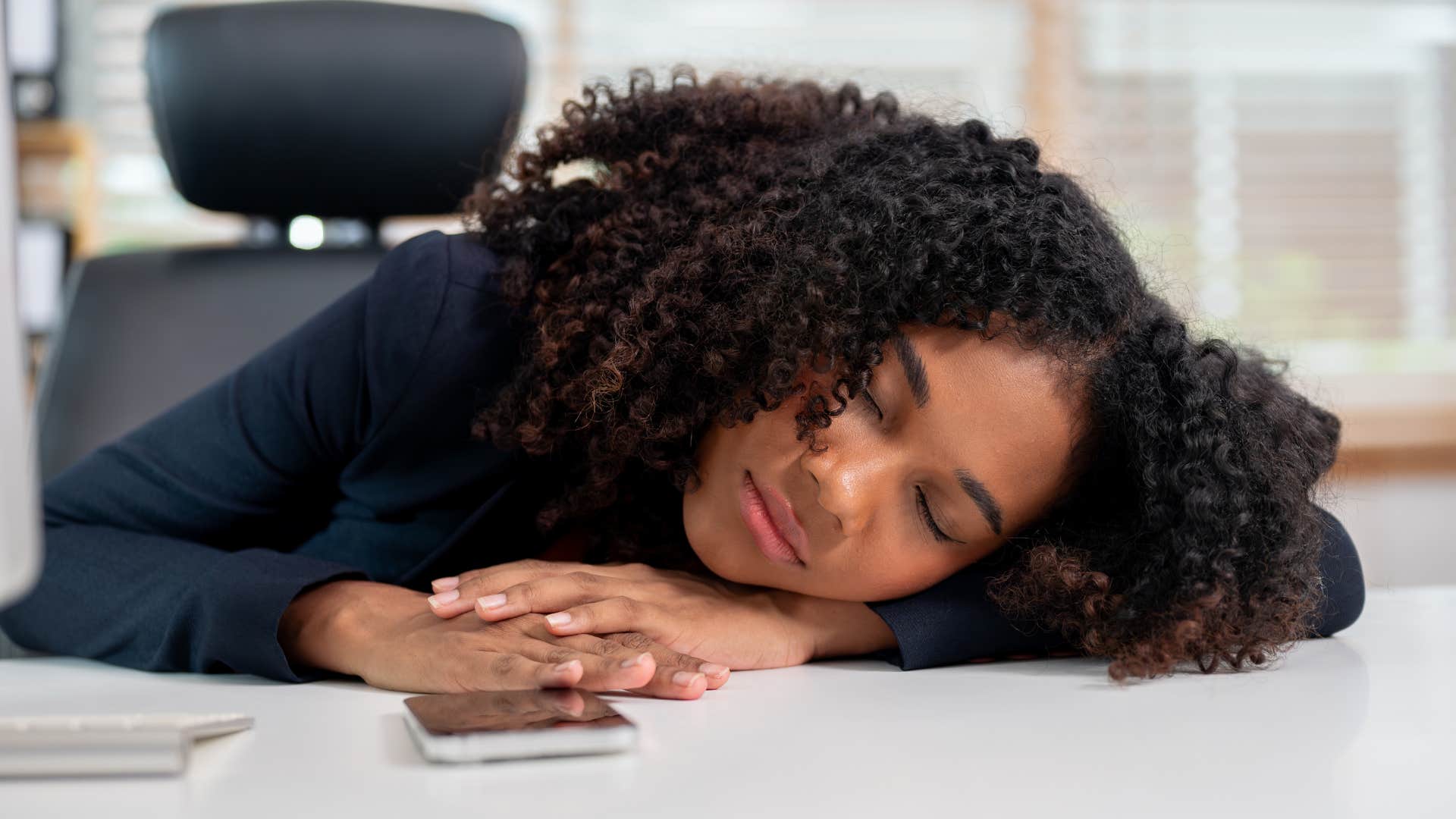 woman who's not motivated by external validation napping at work