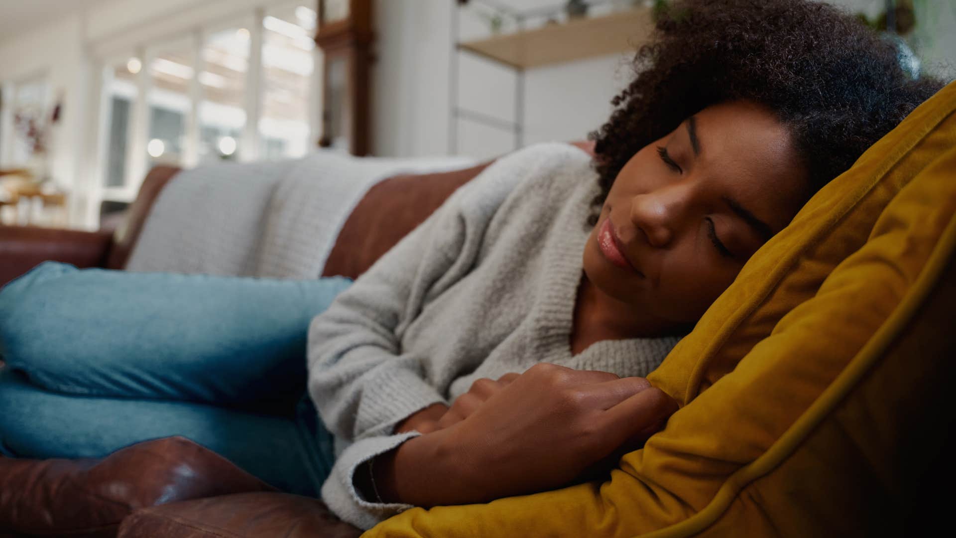 reflective woman sleeping on the couch peacefully