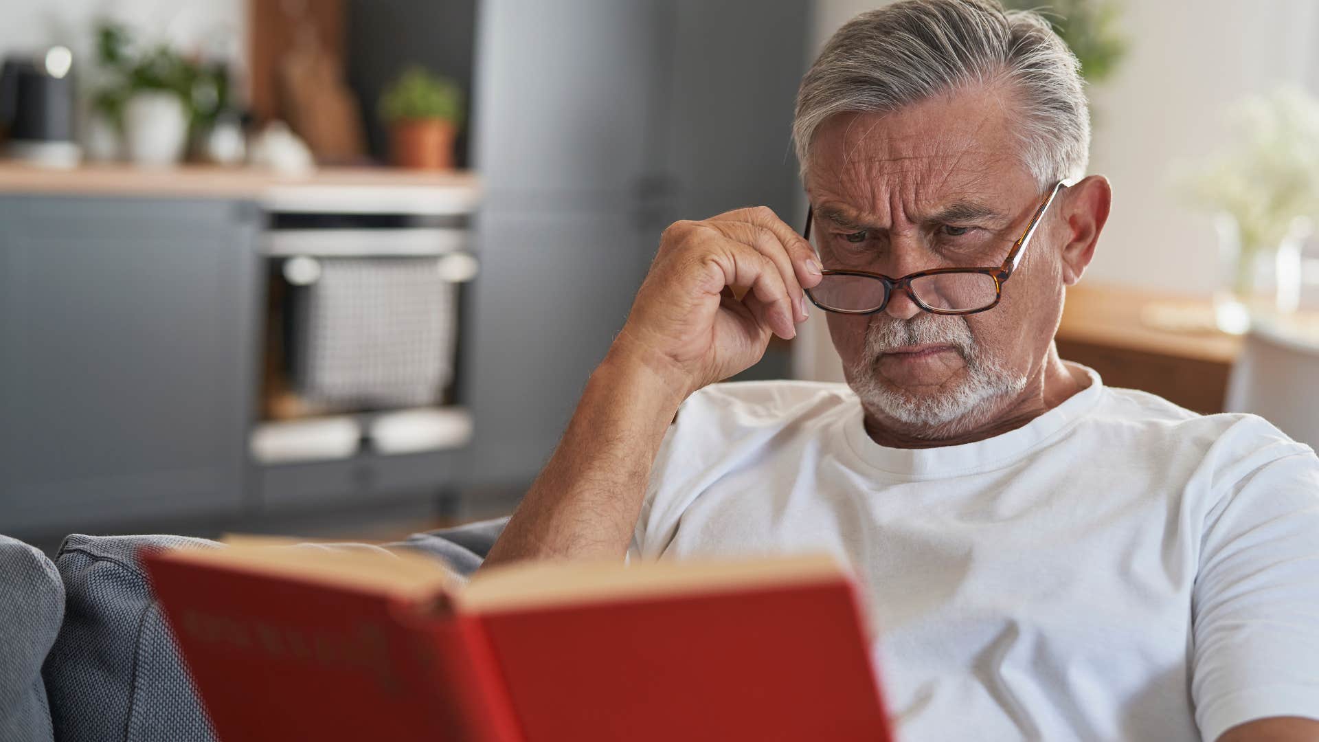 intelligent man reading challenging books sitting at home