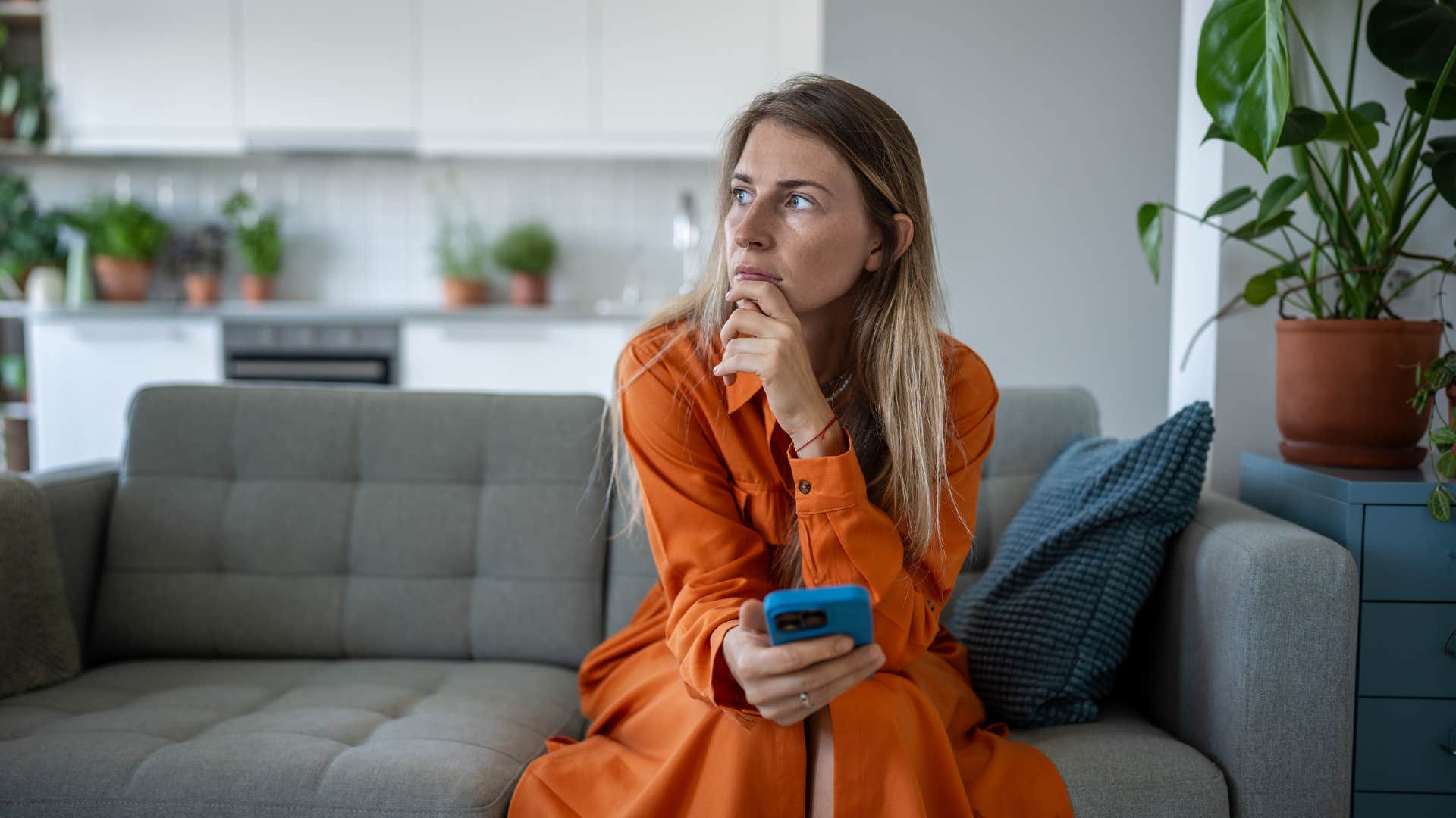sad woman texting no to plans from her couch