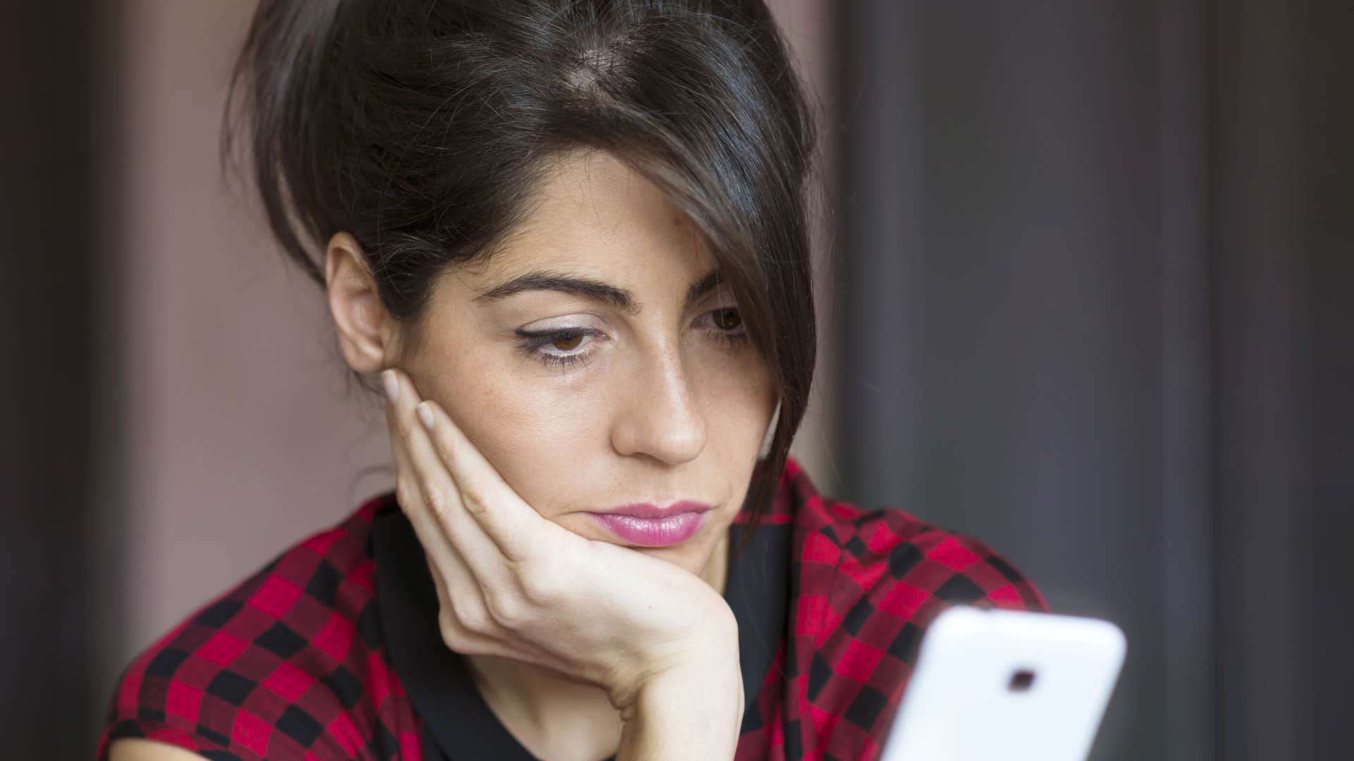 sad woman avoiding making plans on her phone