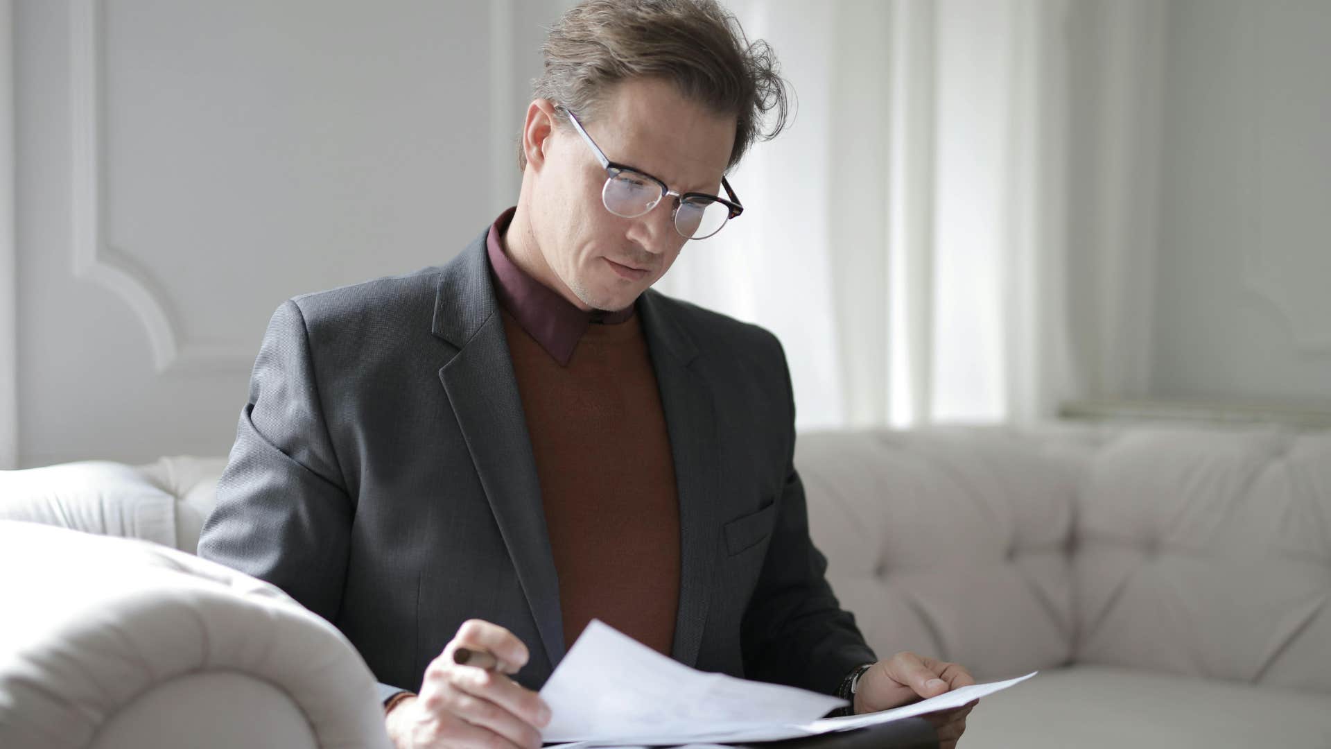 man saying he needs time to think about this looking at papers