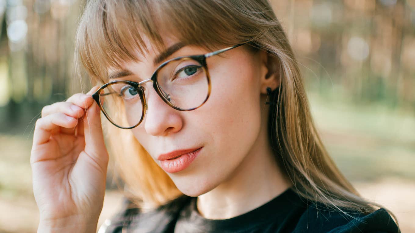highly analytical woman touching her glasses