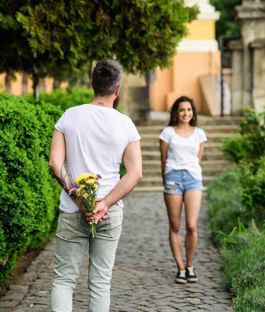 man surprising woman with flowers on first date
