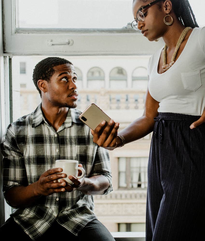 Serious woman confronts man about social media showing person on rebound