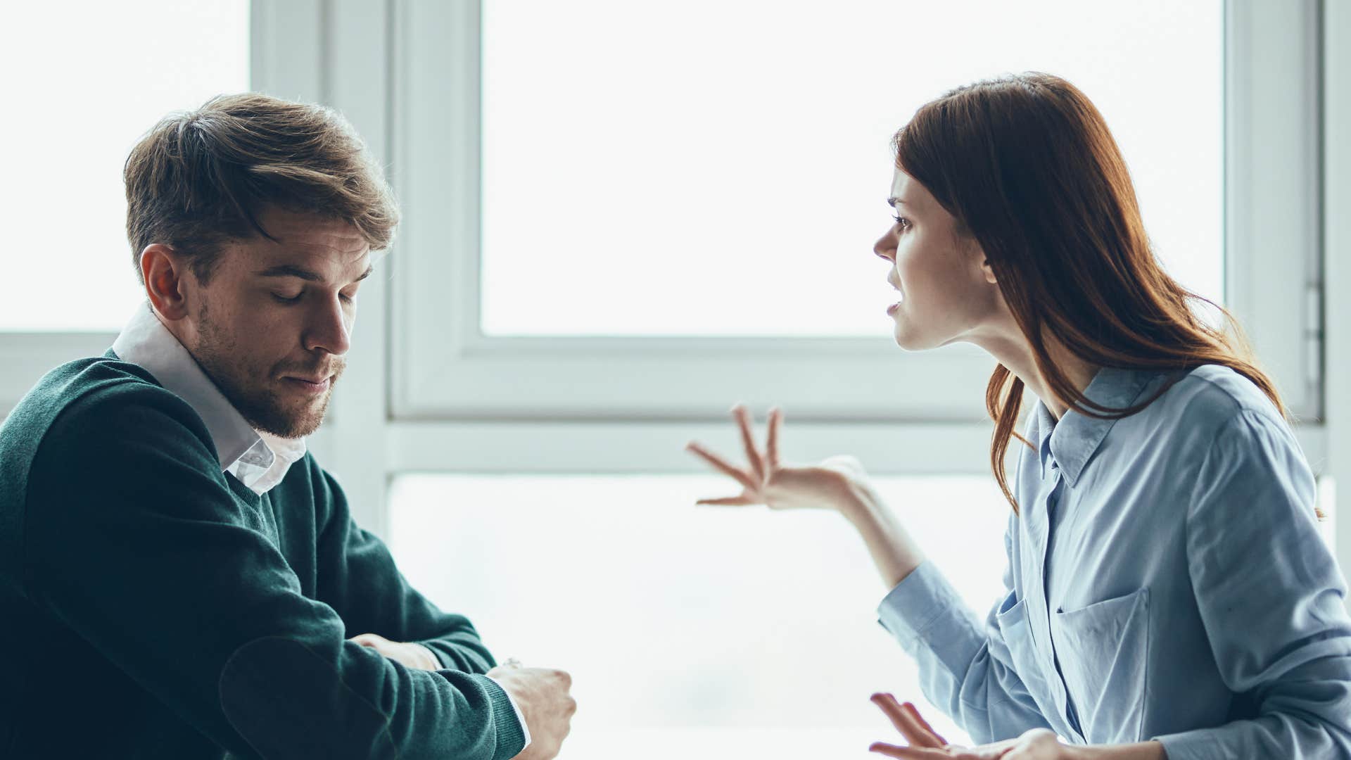 woman arguing with man as he looks away and does his best to avoid conflict