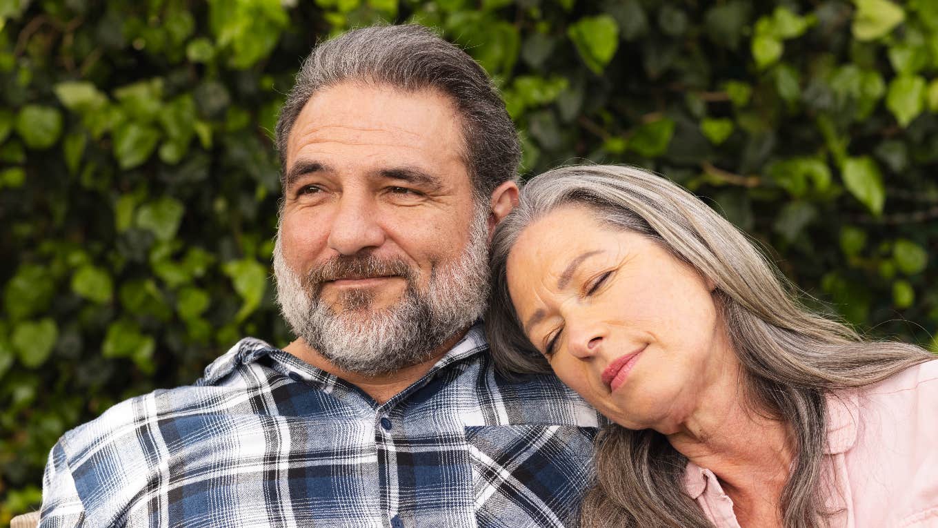 woman resting head on man's shoulder