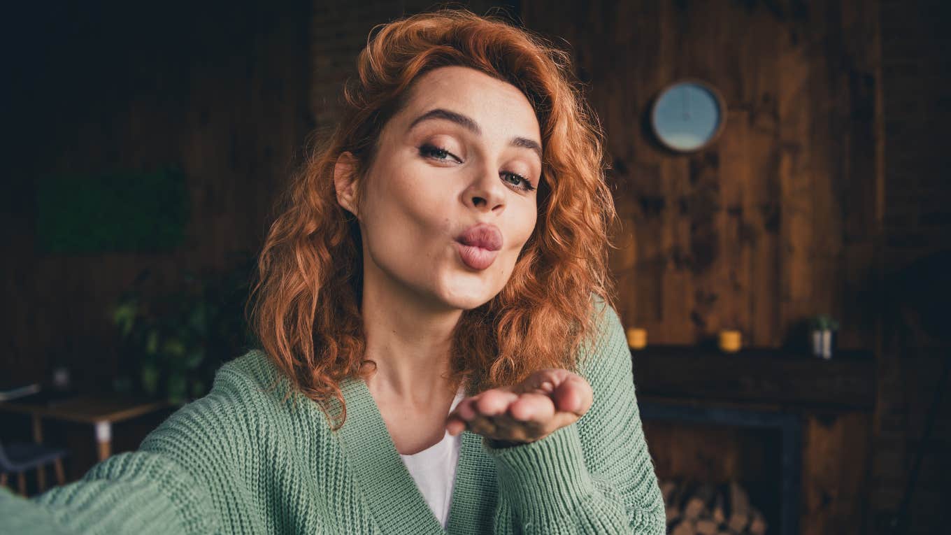 self-centered woman blowing a kiss at home