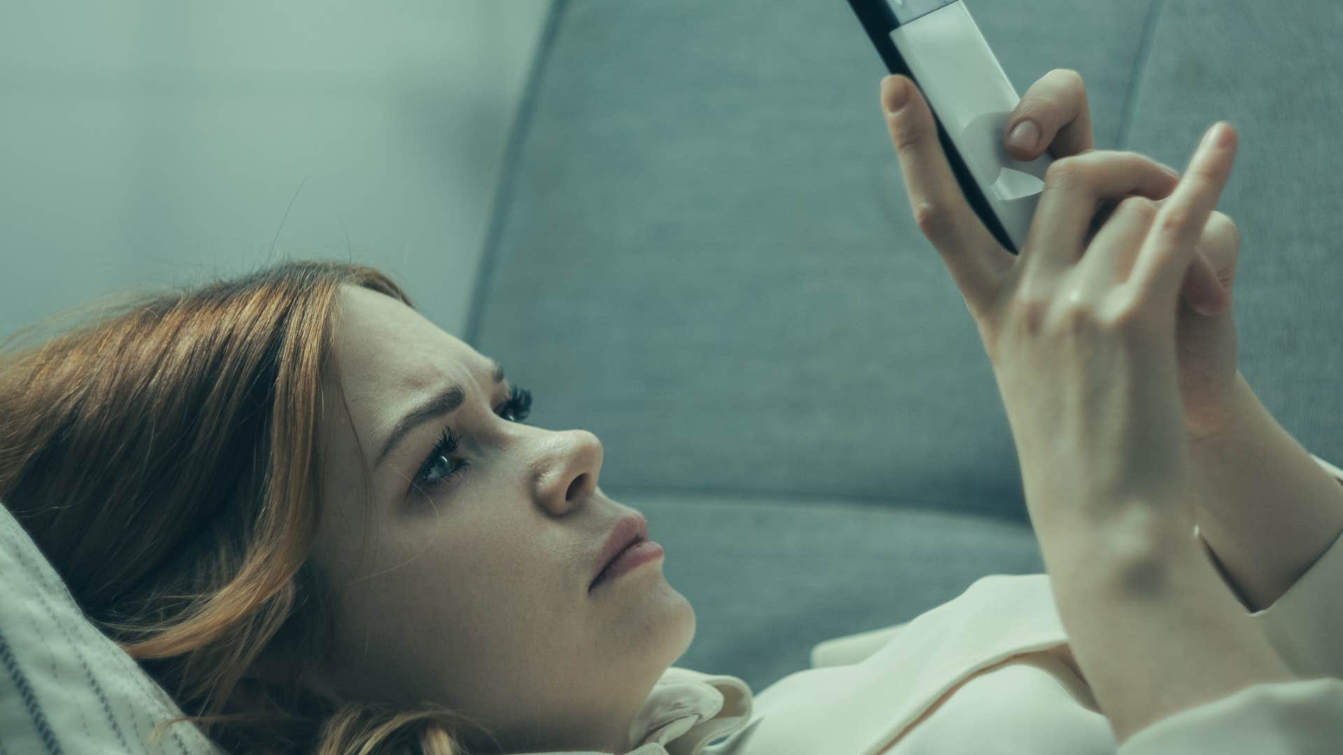 self-centered woman doomscrolling on her phone at home