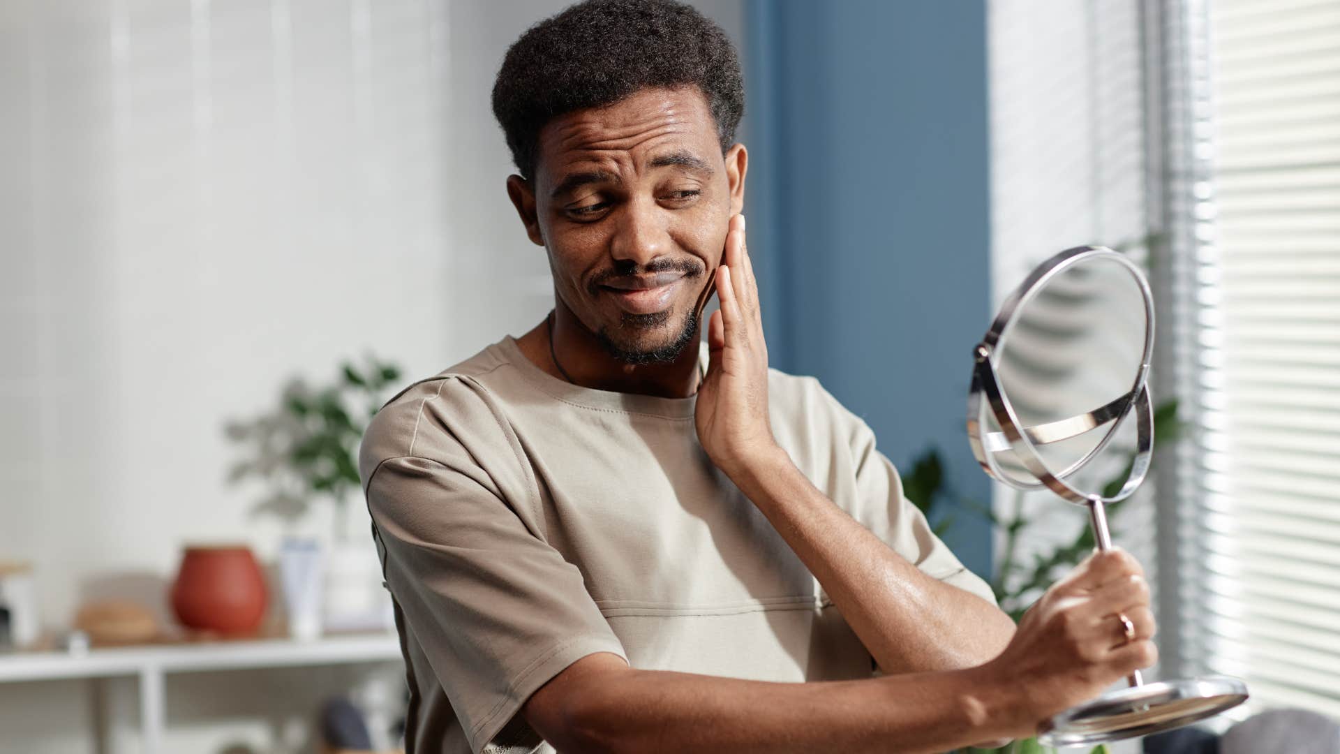 self-centered man looking in mirror imagining the compliments he'll receive