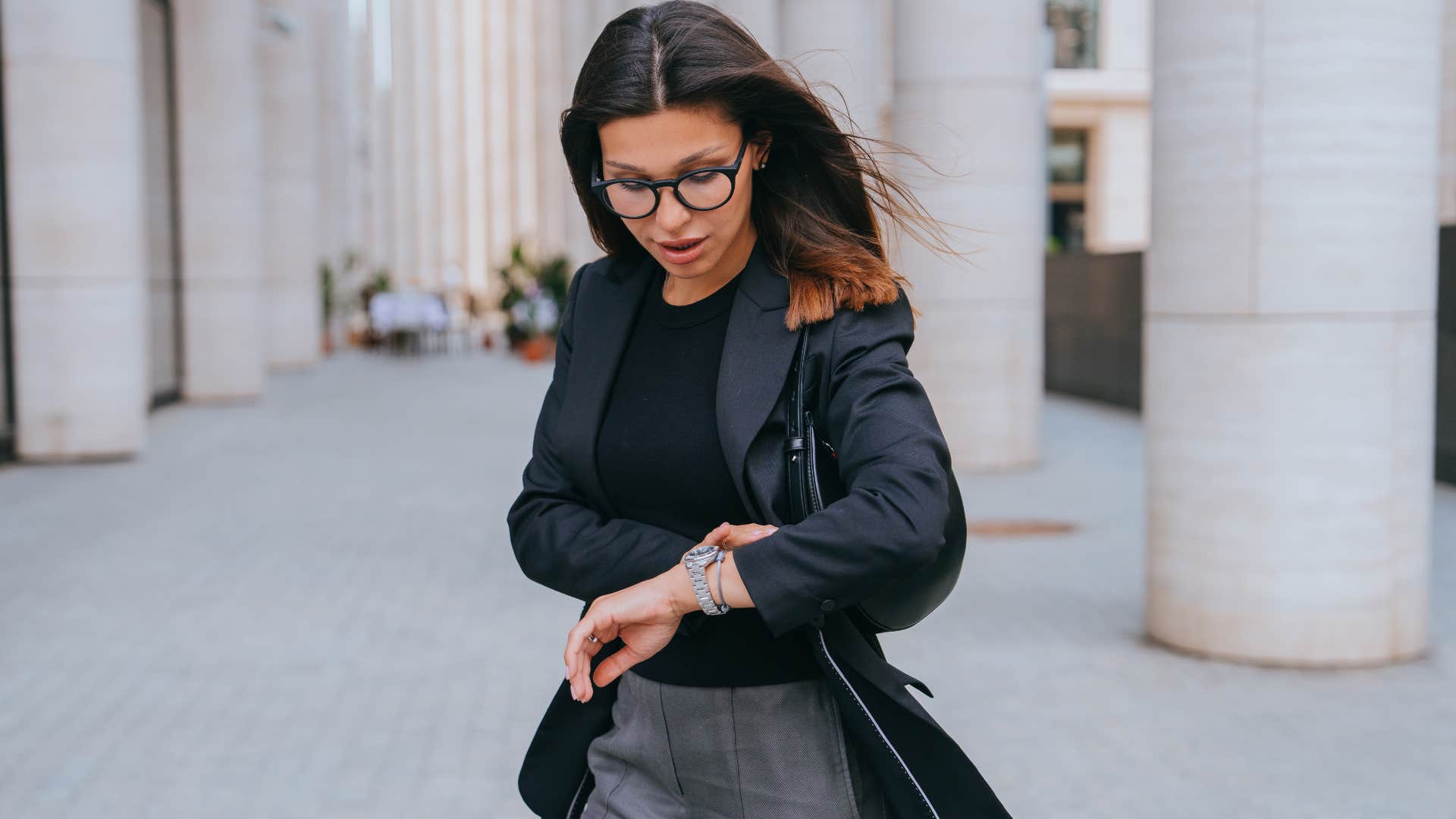 woman checking her watch after leaving without saying goodbye