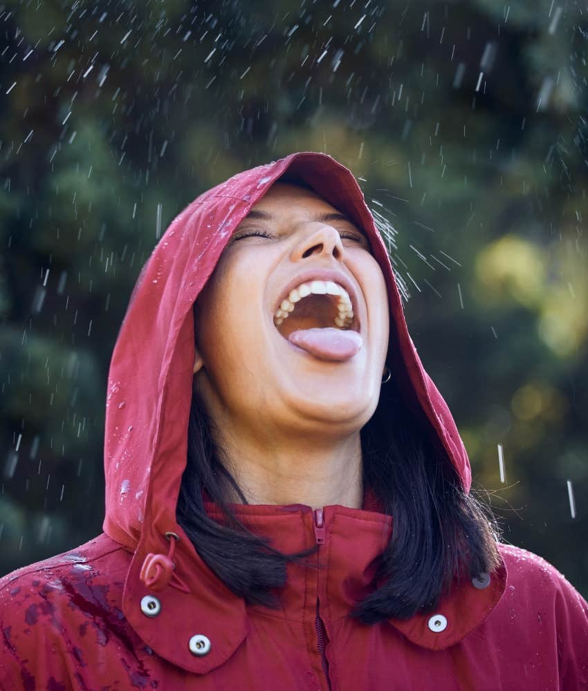 Joyful person catches raindrops on tongue showing time in nature changes life