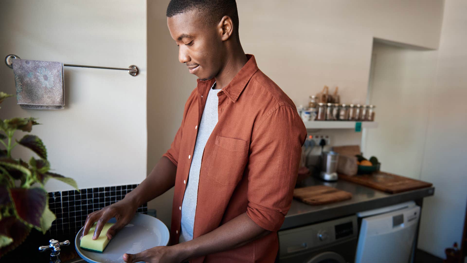 man cleaning up his dishes