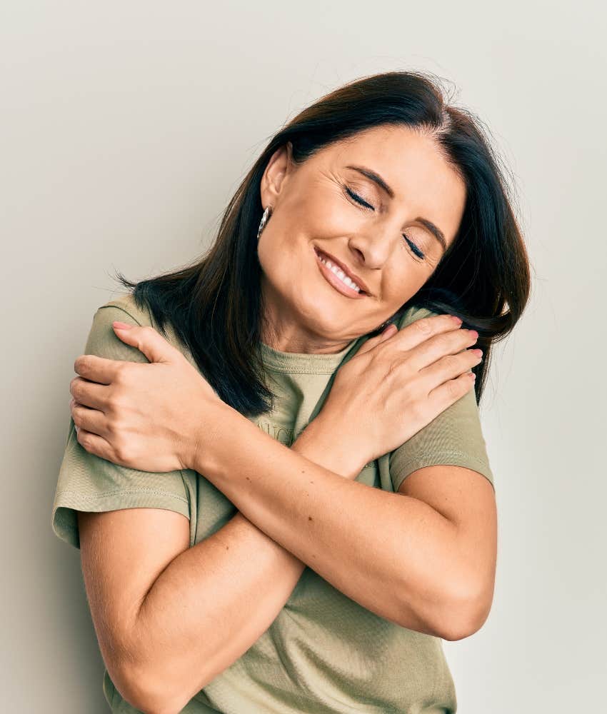 Happy person hugs themselves showing importance of self-care