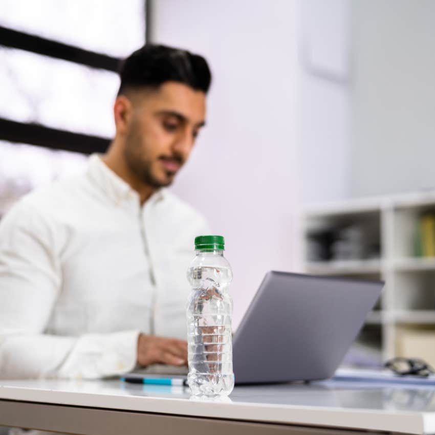 man who will be a happy person this holiday season with keeping bottle of water on desk