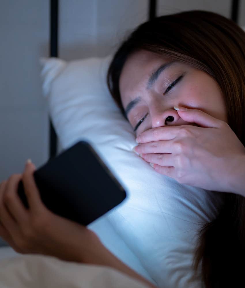 Tired person scrolls on phone in bed showing sensitive person takes world personally