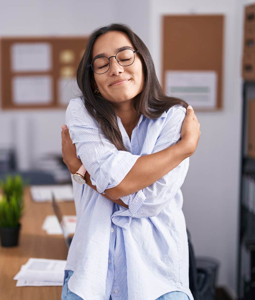 Person hugs self showing credit for being unflappable
