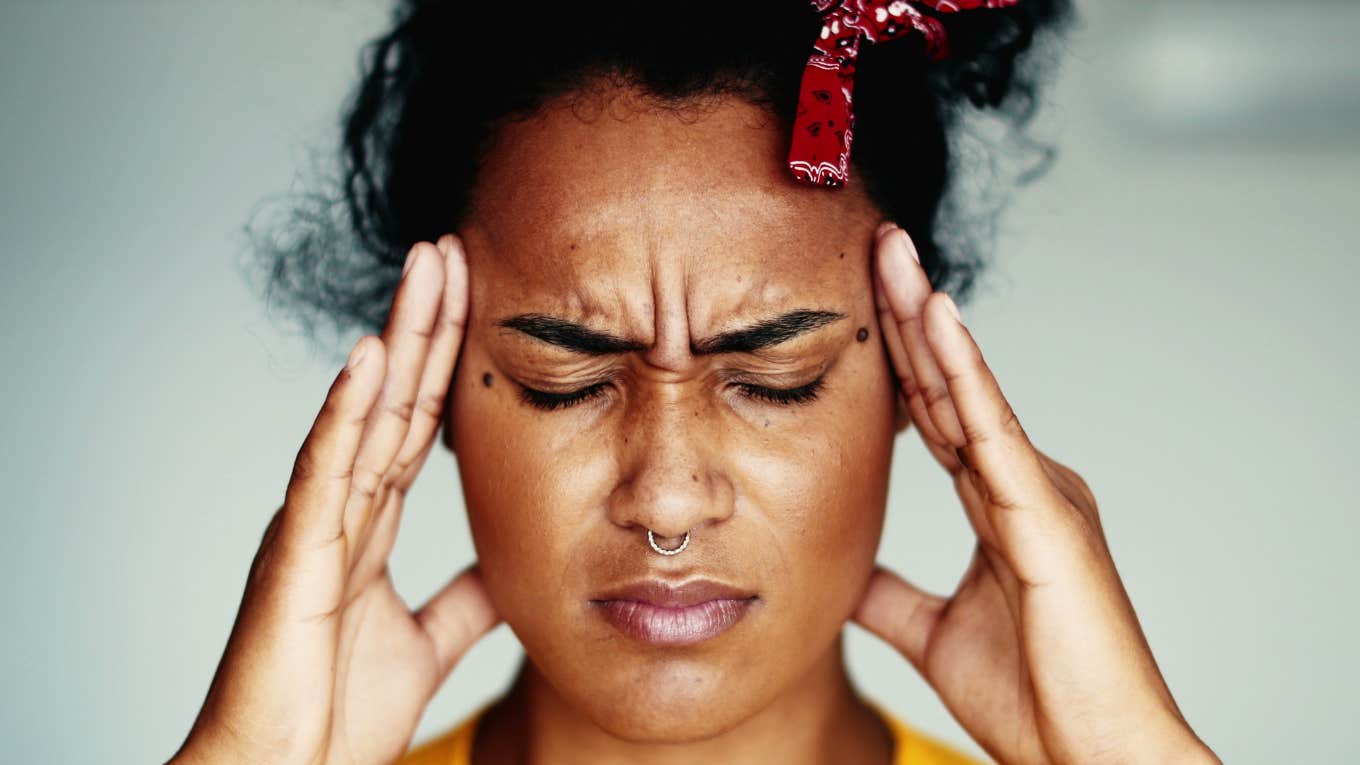 young woman feeling stressed out holding her head