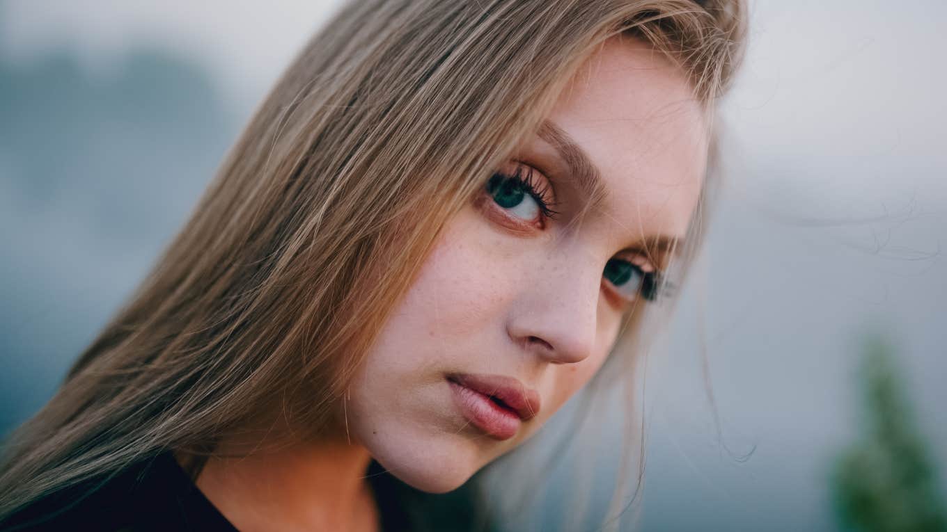 serious woman with a hidden cruel streak thinking