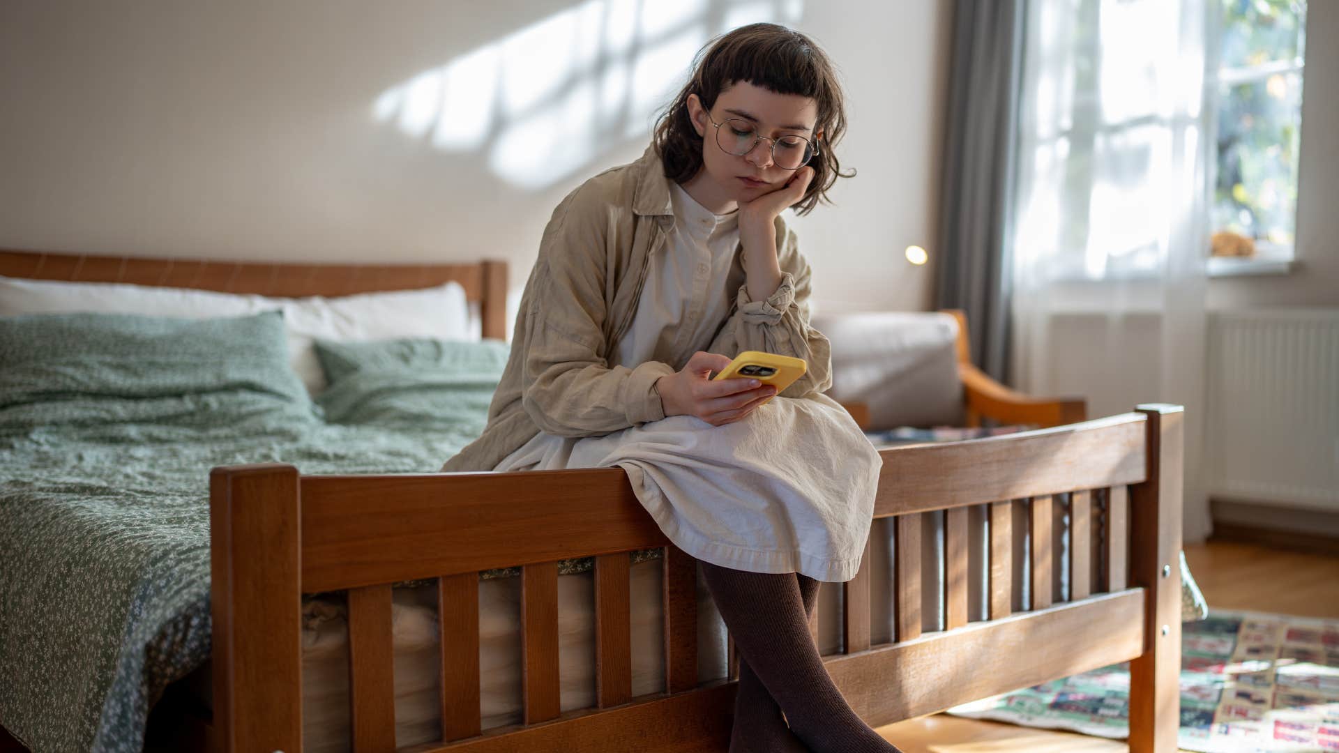 sad lonely young person looking at phone not calling loved ones