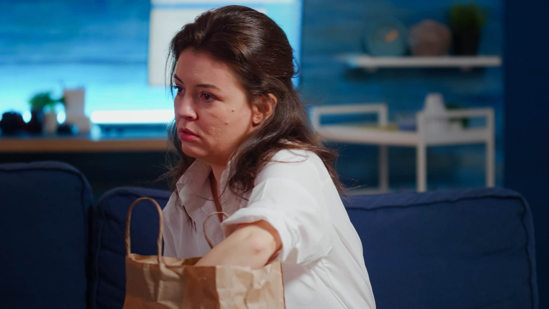 sad woman reaching into takeout bag instead of cooking