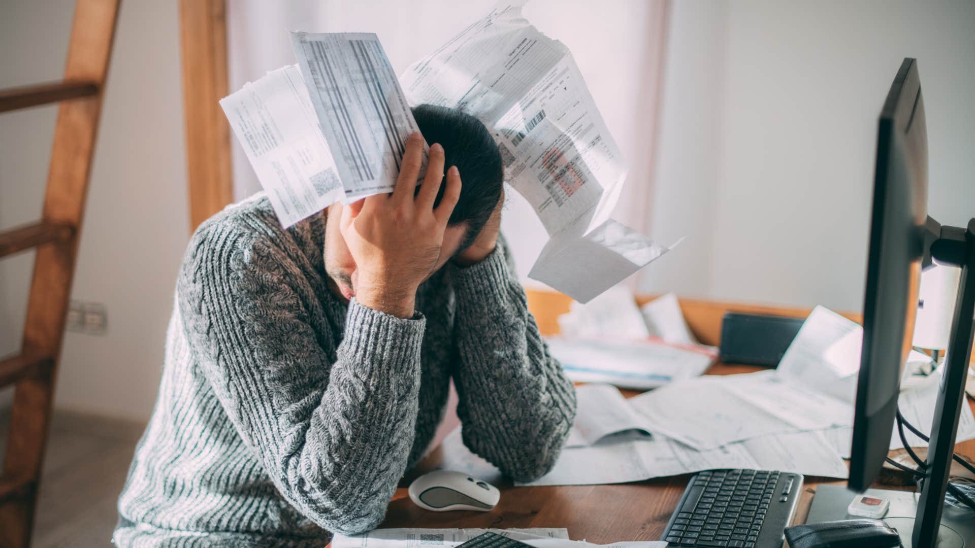 man overwhelmed with unpaid bills
