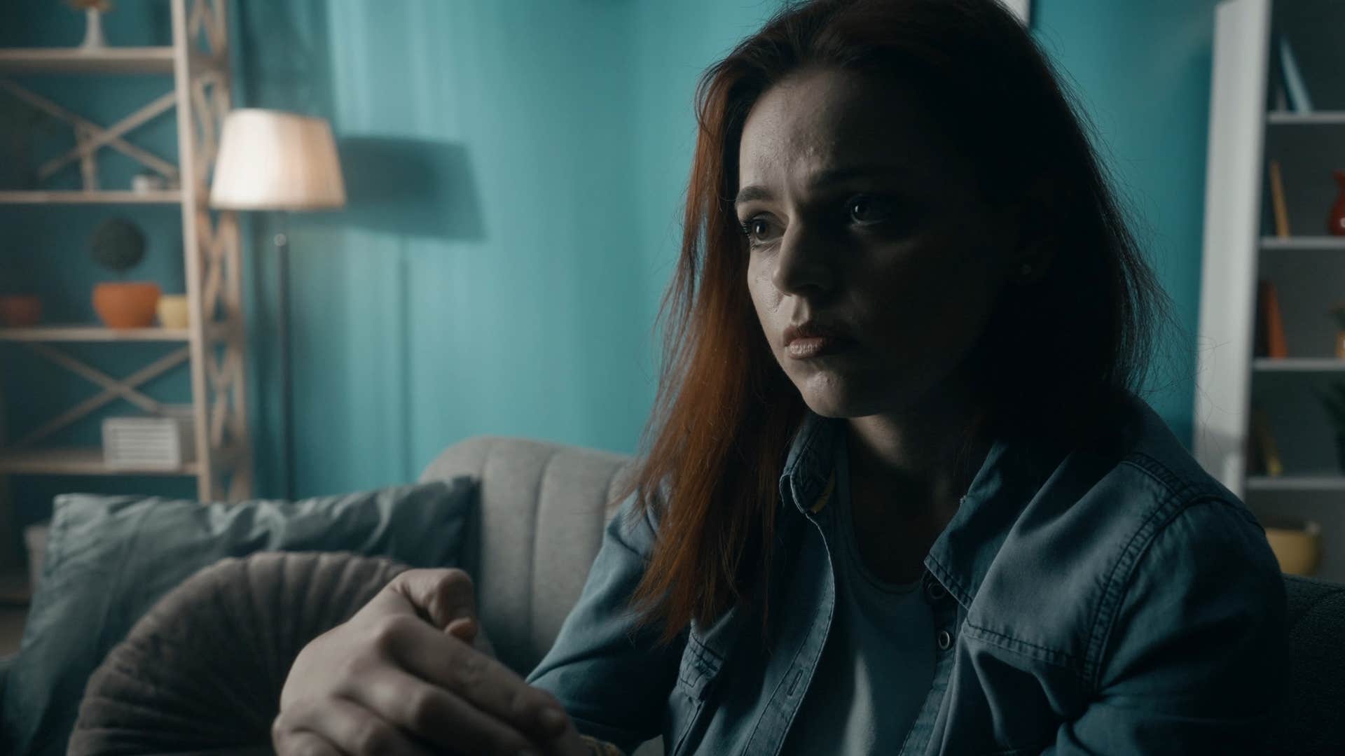 sad woman sitting in dark room after not changing burned out light bulbs