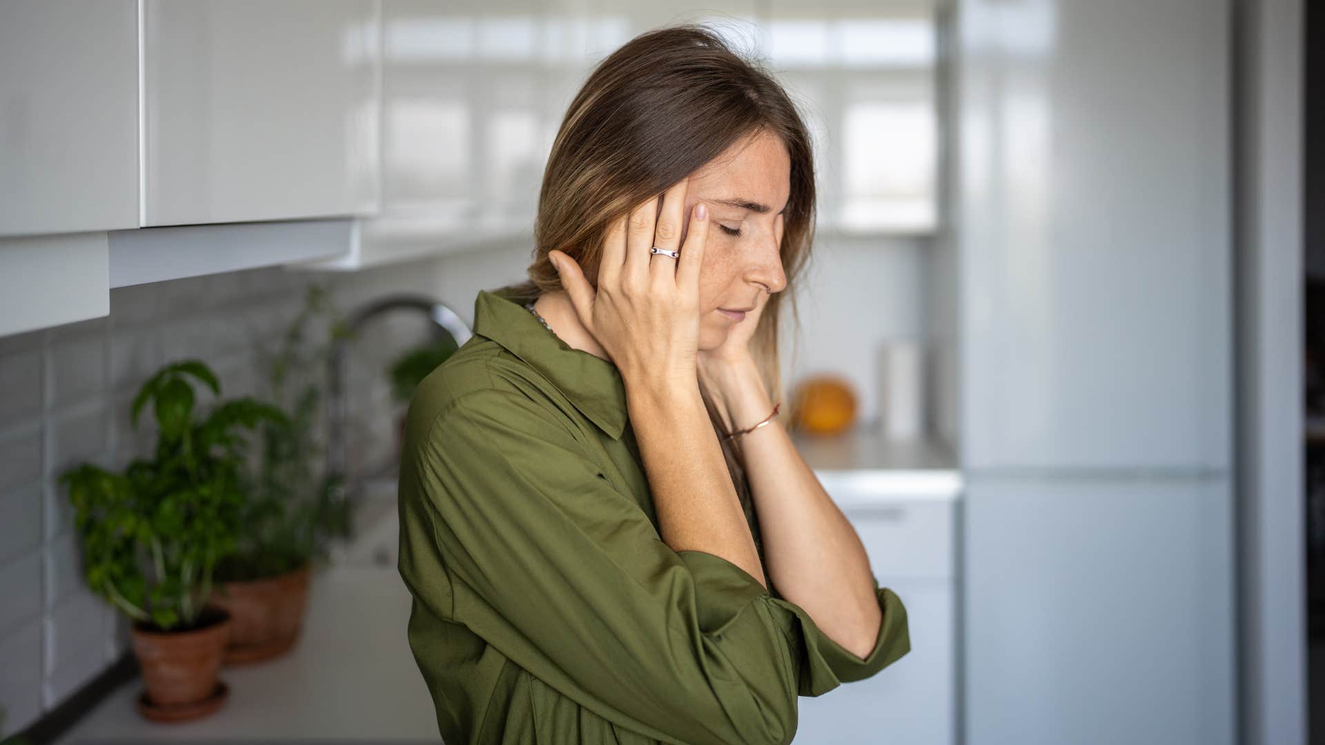 tired woman looking stressed in her kitchen