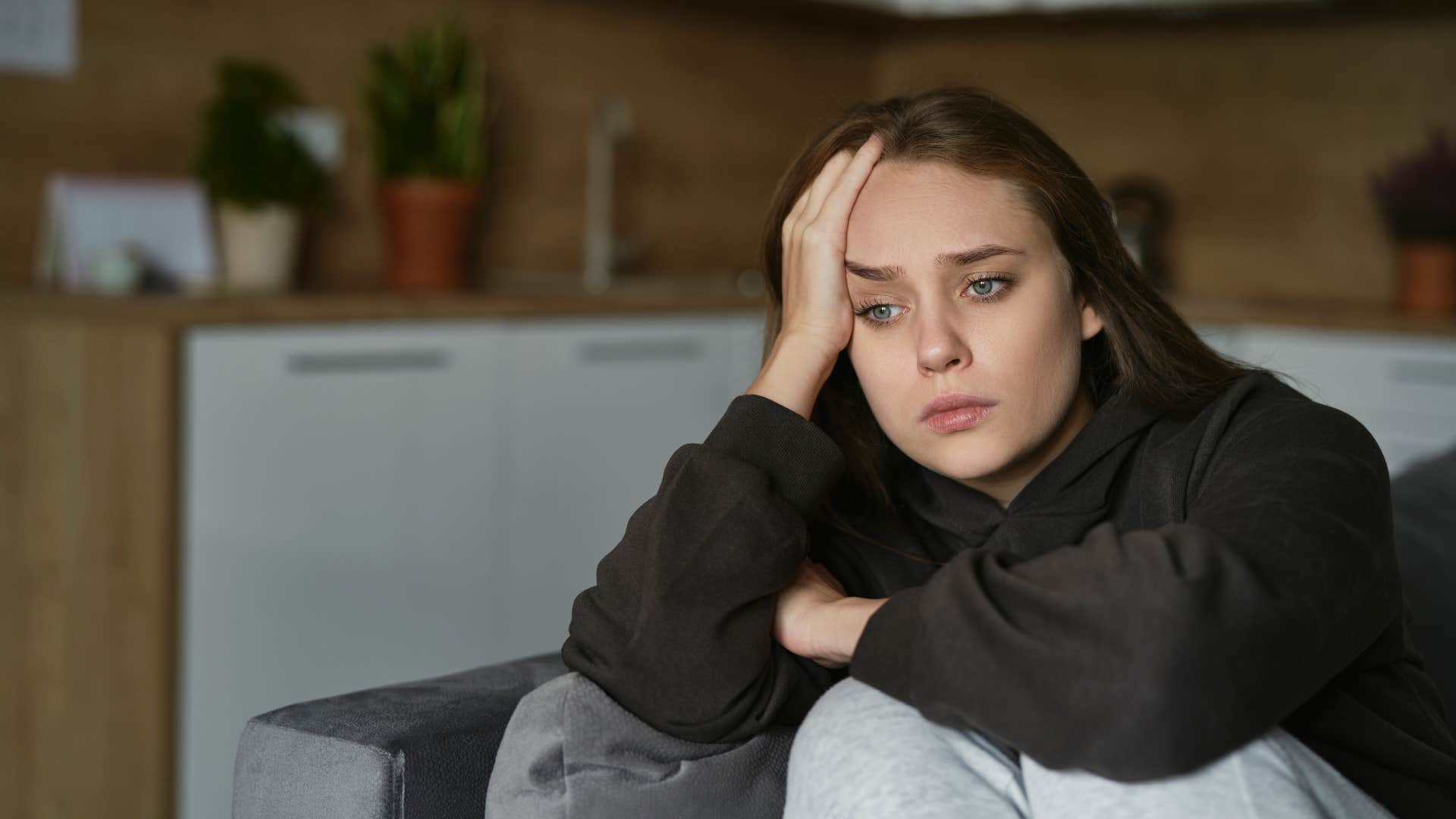 sad woman sitting at home thinking nobody cares