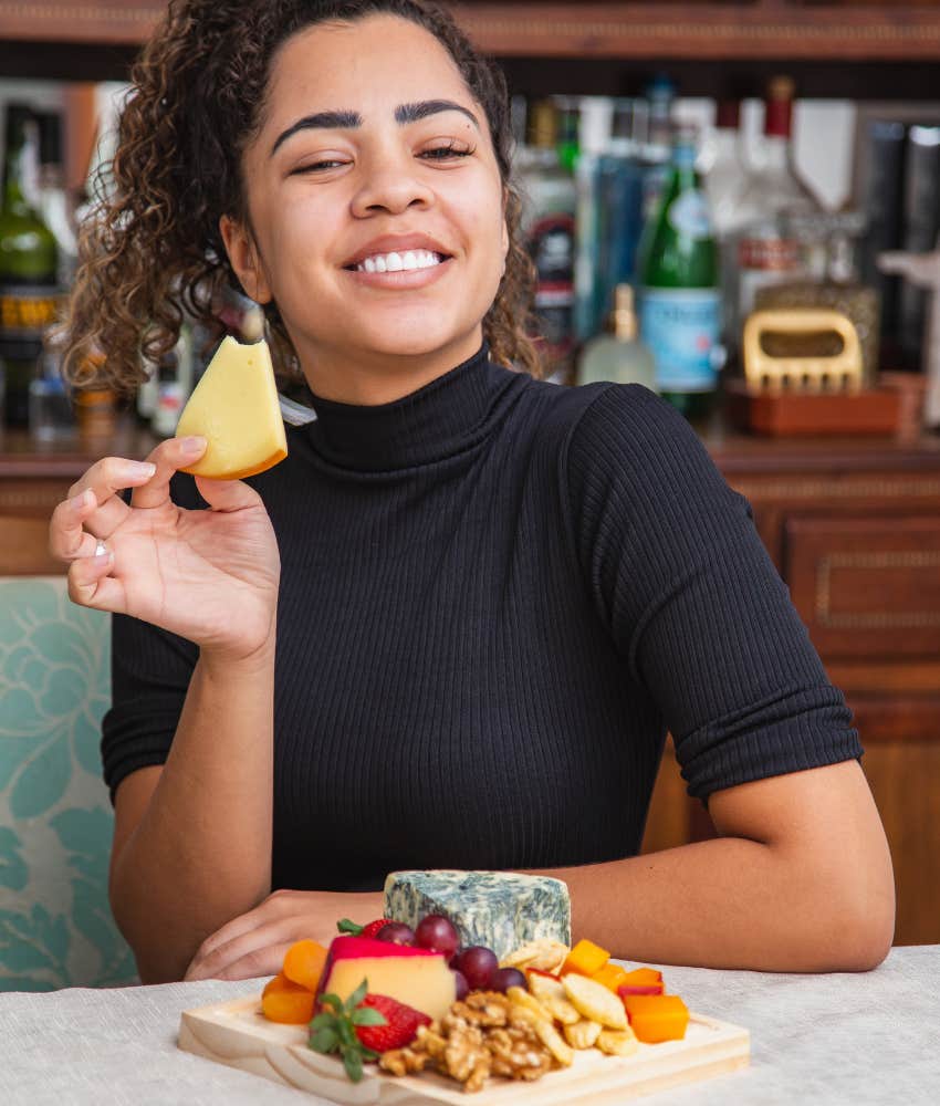 Woman eating cheese because her dairy cravings mean she longs for her mother's love
