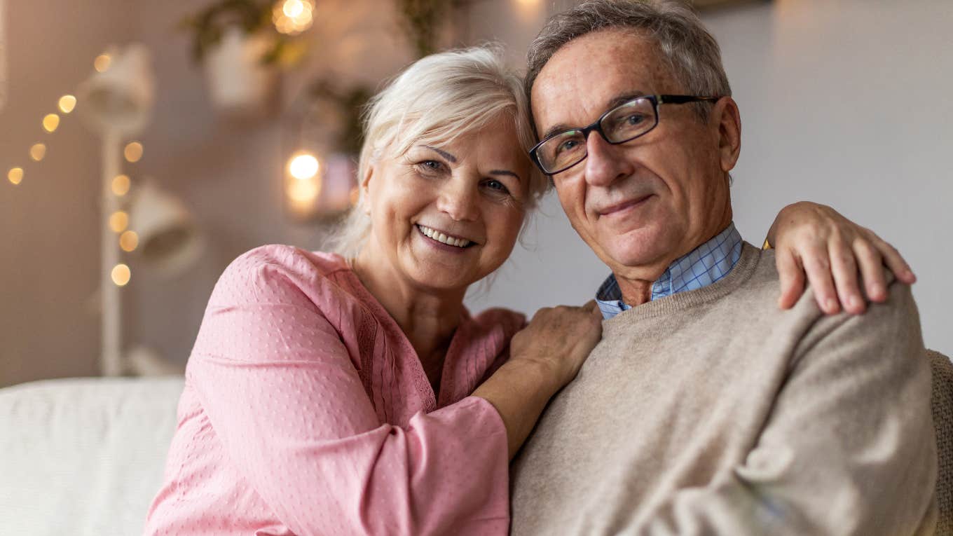 upper middle class older couple sitting comfortably in their home