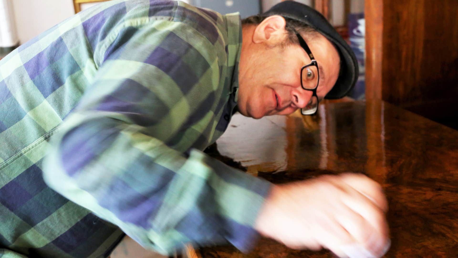 man polishing giant oak furnishings at home