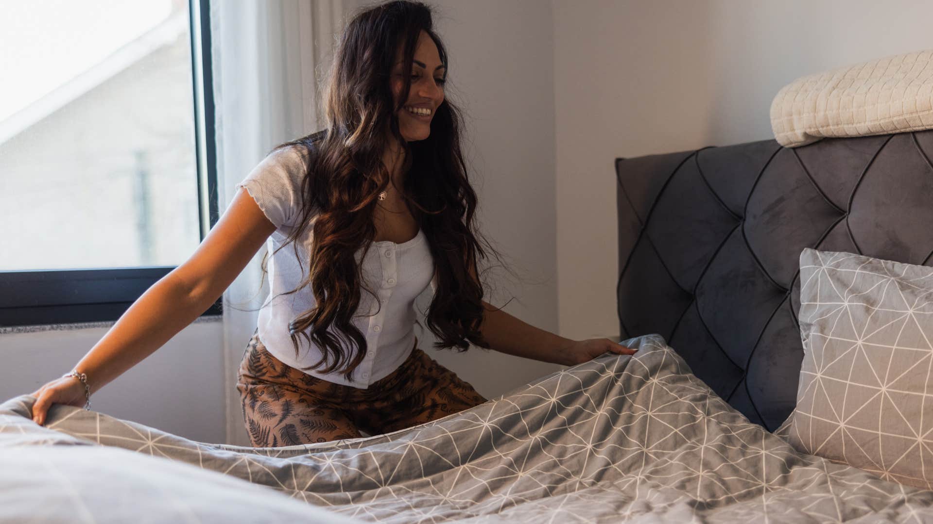 woman making a bed in her guest room