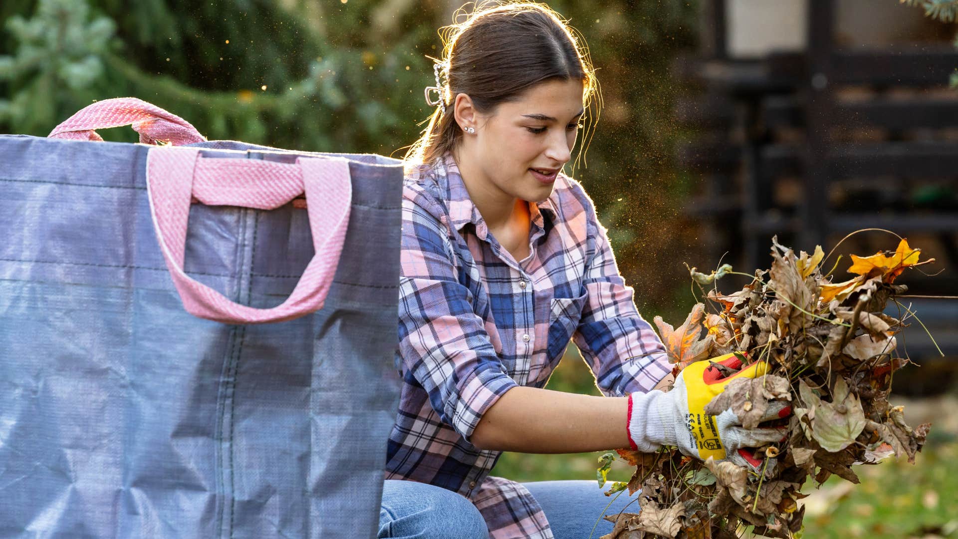 woman cleaning up leaves in her landscaped front yard