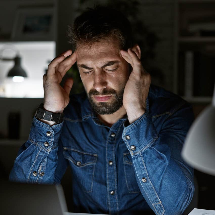 stressed man who feels chronically behind fighting a migraine