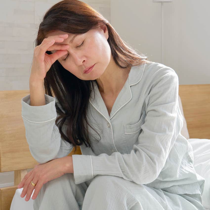 stressed woman waking up tired and anxious sitting in bed