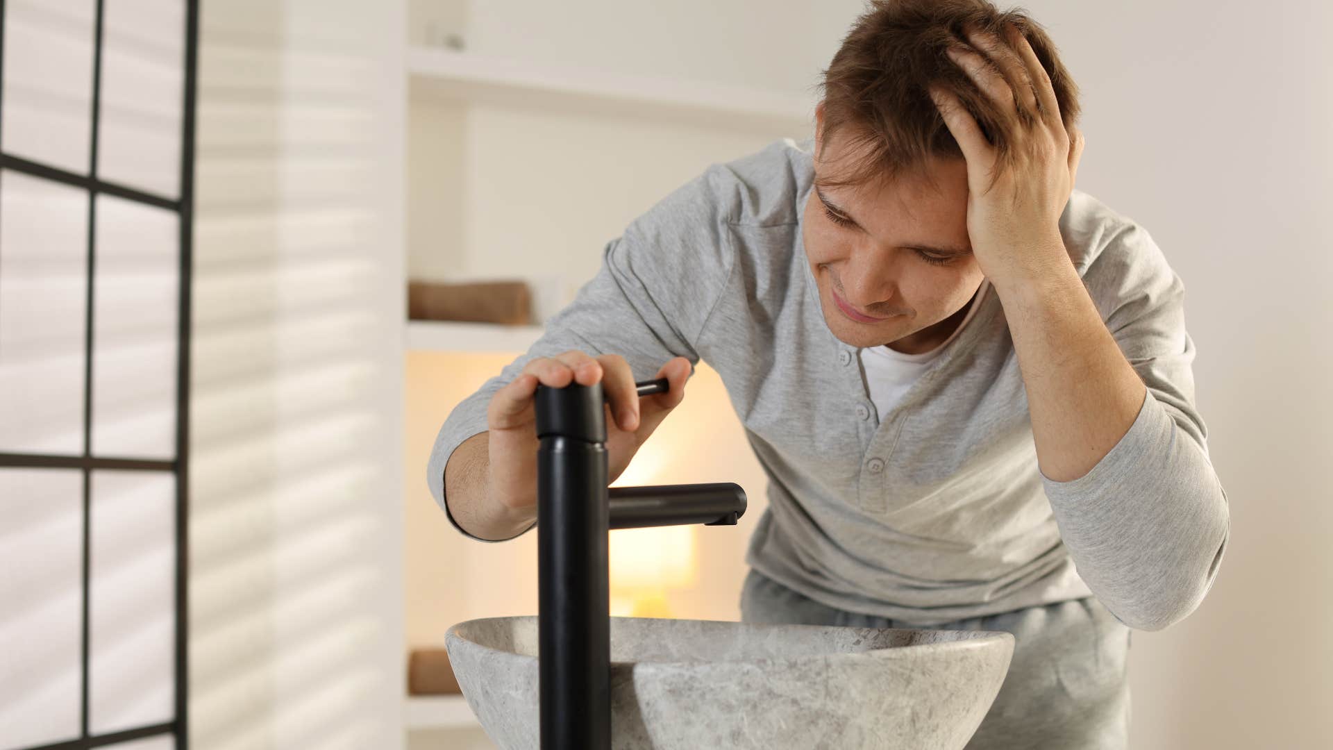 unhappy man looking at sink