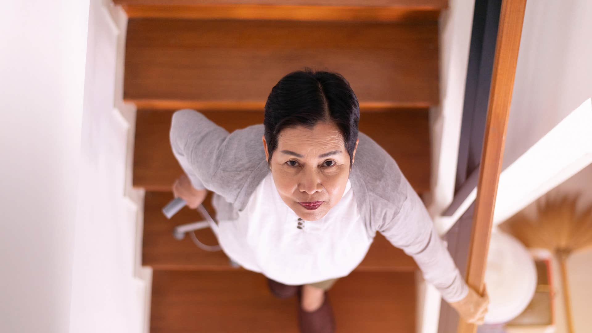 woman holding onto railing while going down stairs