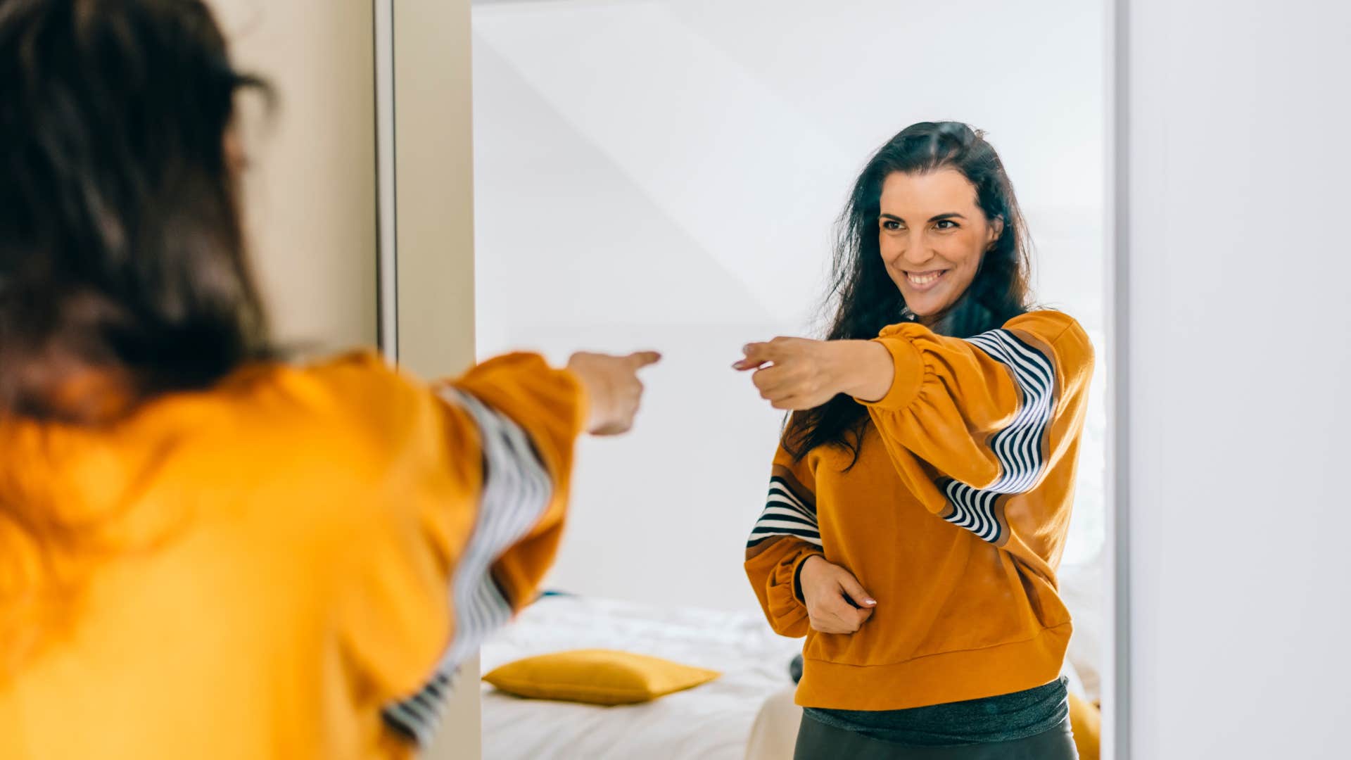 woman speaking kindly to herself in the mirror
