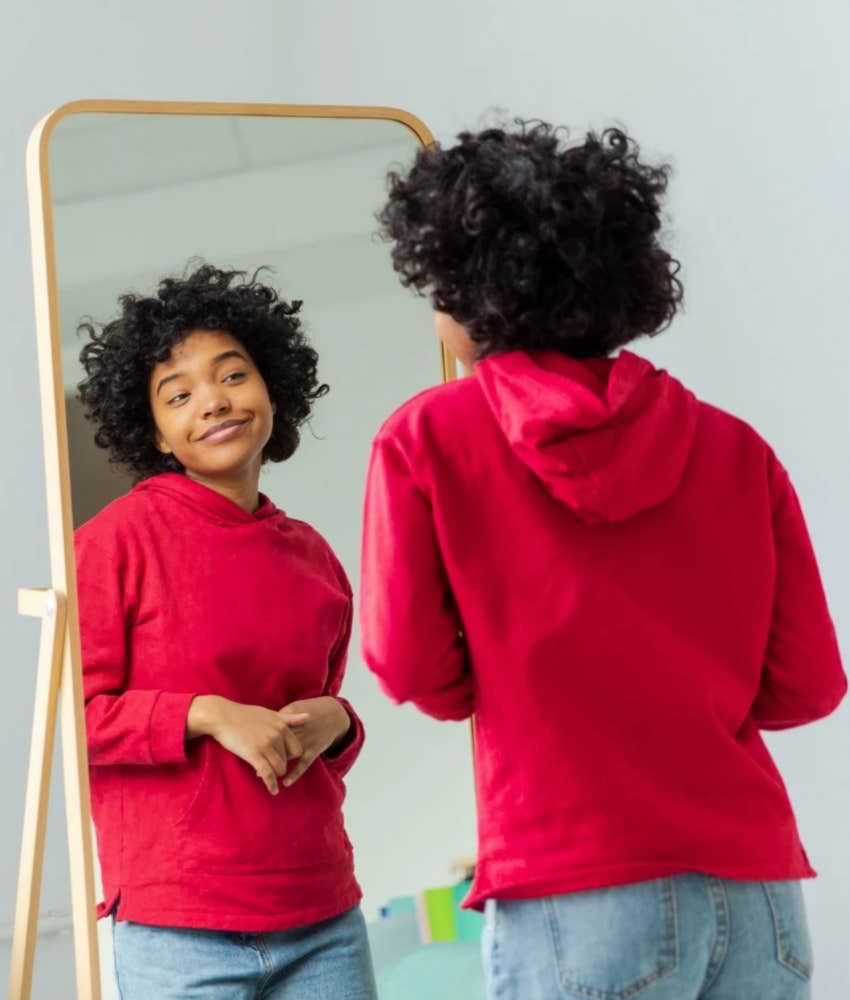 Successful woman looking in the mirror, smiling and true to herself 