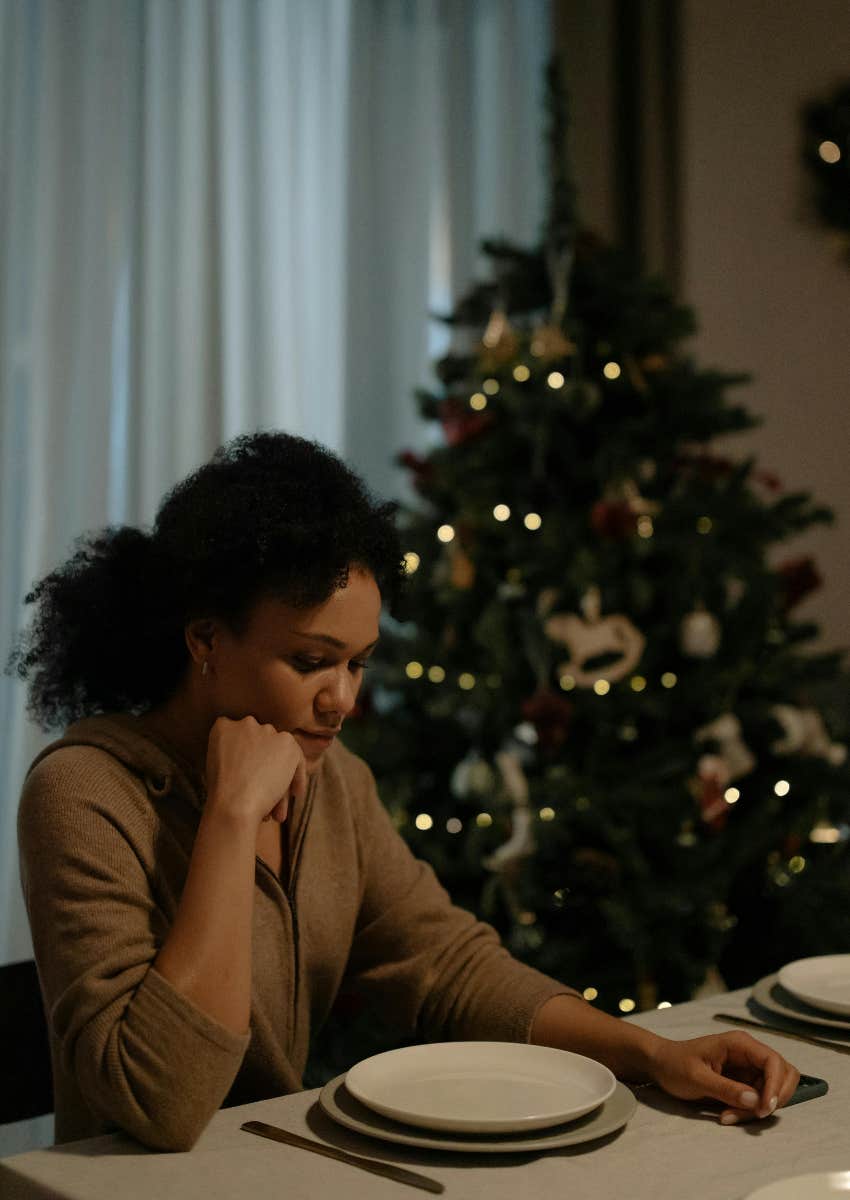 upset gen z woman sitting at the table for Christmas dinner