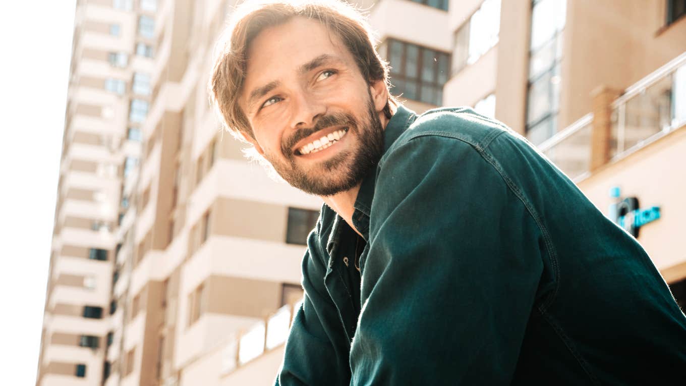 Man smiling softly with genuine warmth showing the sweet ways real men describe what it feels like to fall in love.