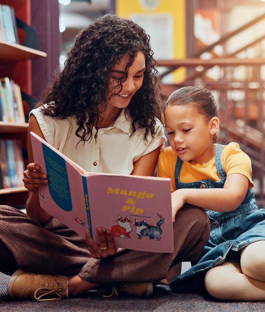 teacher helping student read book