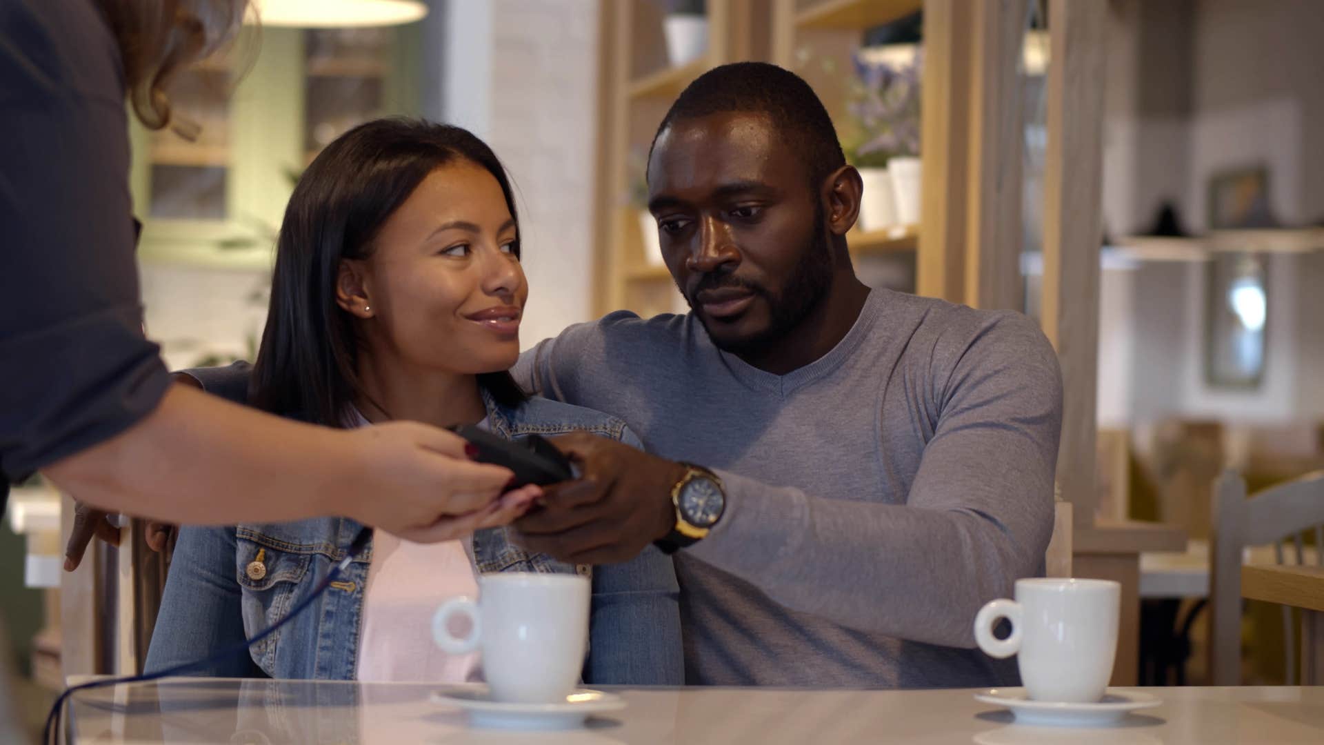 woman smiling at man and refusing to make it awkward as the host pays